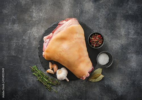 Raw Eisbein or ham hock, or Schweinshaxe with spices.  Fresh raw pork knuckle preparing to cooking.