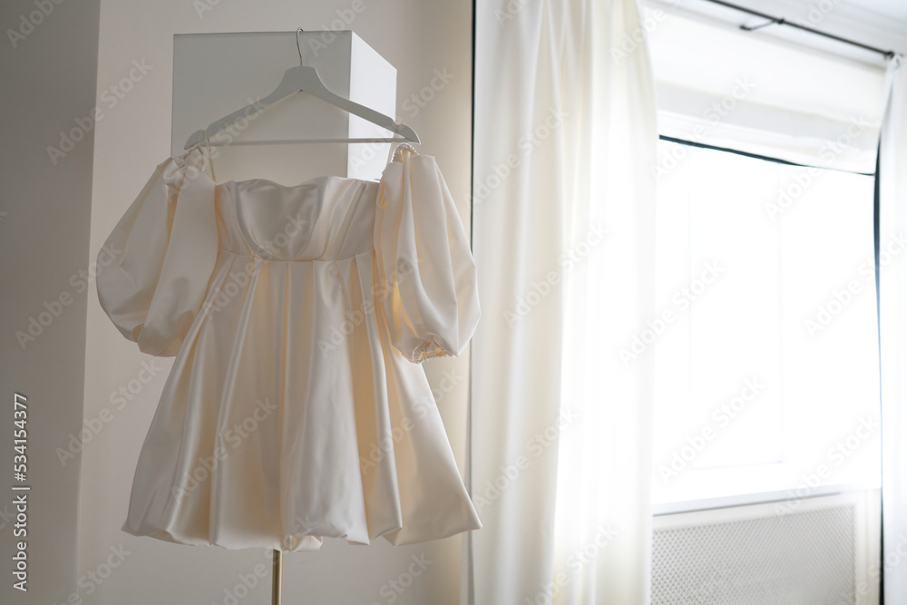 short wedding dress. wedding dress hanging on a floor lamp short wedding dress. wedding dress hanging on a floor lamp