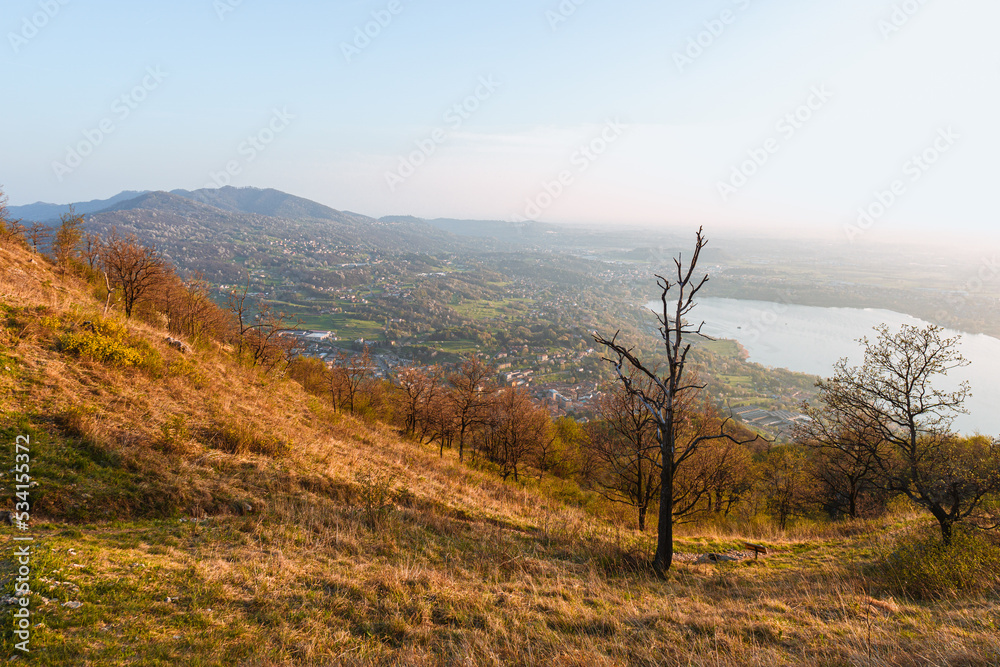 the alps, lakes and cities of brianza seen in the sunset light from the top of mount Barro, near the town of lecco, Italy - April 2022.