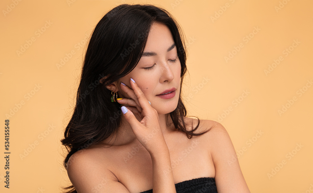 Tender woman touching face in studio Tender woman touching face in studio