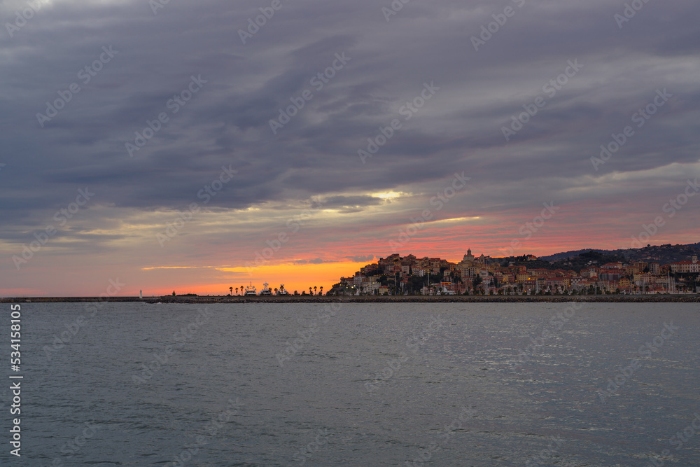 Clouds at sunset with Imperia cityscape, Liguria region, Italy