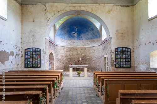 interior of the old abandoned church with stone walls, view from behind the pews to the presbytery and altar