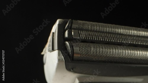 Shaving part of an electric razor, rotation close-up. photo