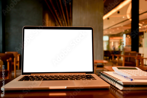 close up on isolated blank screen laptop with stationary on the table in cafe restaurant for website template design concept