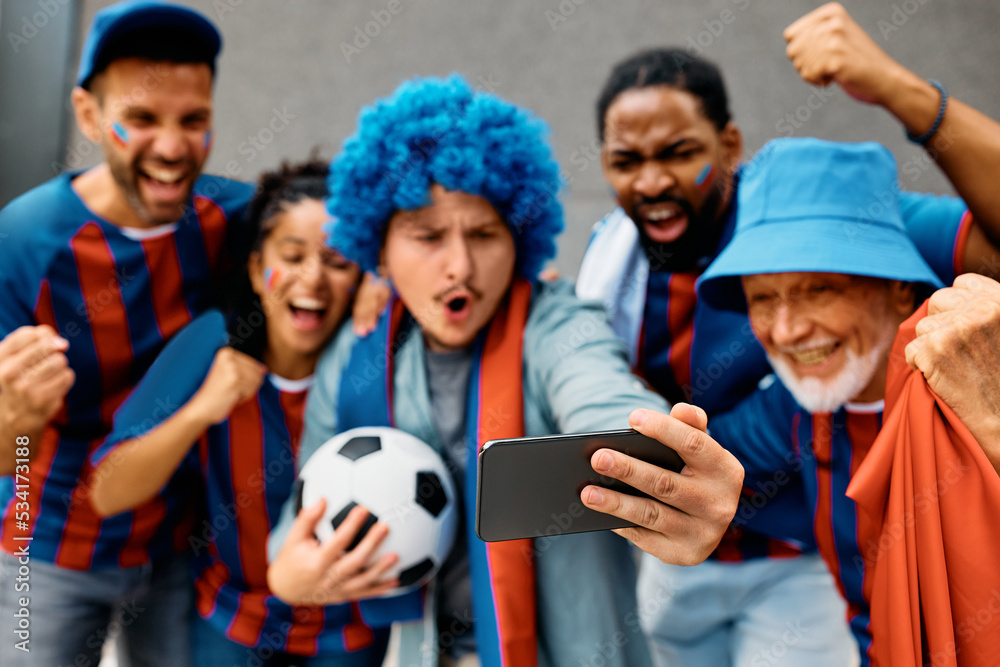 Obraz premium Close up of soccer fans watching game on smart phone.