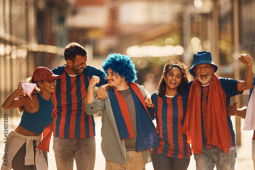 Group of happy sports fans celebrate victory of their favorite team on street.
