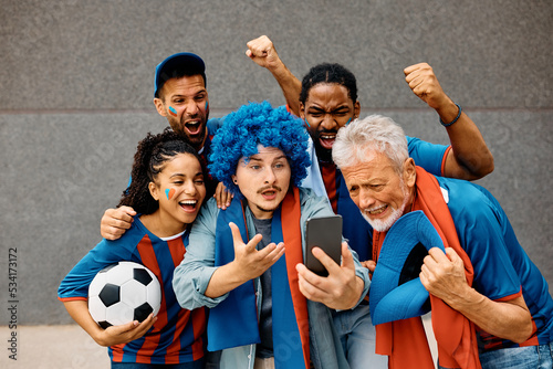 Sports fans watching football match via live stream on mobile phone.