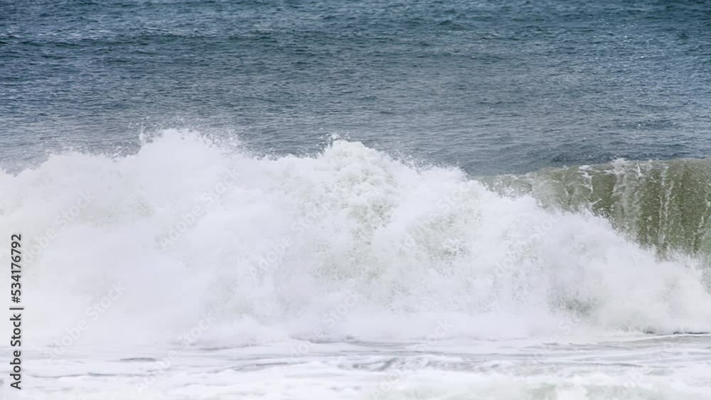 Pan of white water from an aggressive crashing wave in slow motion in the shore with a deep dark blue ocean behind it and white water spilling in high speed camera 120fps 4K footage. Pan of white water from an aggressive crashing wave in slow motion in the shore with a deep dark blue ocean behind it and white water spilling in high speed camera 120fps 4K footage.