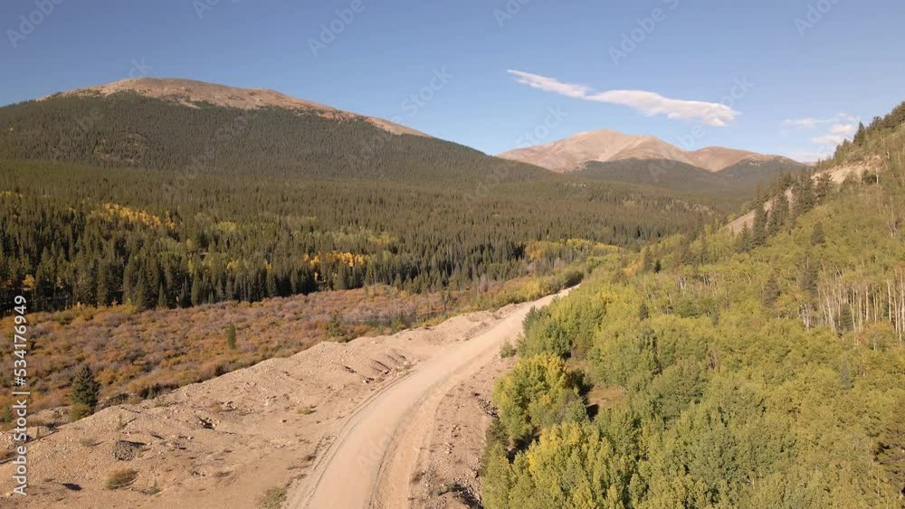 Little Baldy Mountain and Mount Silverheels in the distance as the cameras lifts up above a gravel road. Rocky Mountains in the fall filmed along Boreas Pass Road near the town of Como, Colorado. Little Baldy Mountain and Mount Silverheels in the distance as the cameras lifts up above a gravel road. Rocky Mountains in the fall filmed along Boreas Pass Road near the town of Como, Colorado.