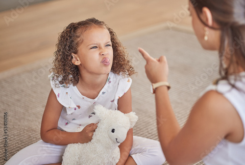 Angry, adhd and child being rude to her mother showing anger, bad behaviour and attitude problems at home. Mean, moody and girl with tongue out making parenting difficult for an annoyed and upset mom photo