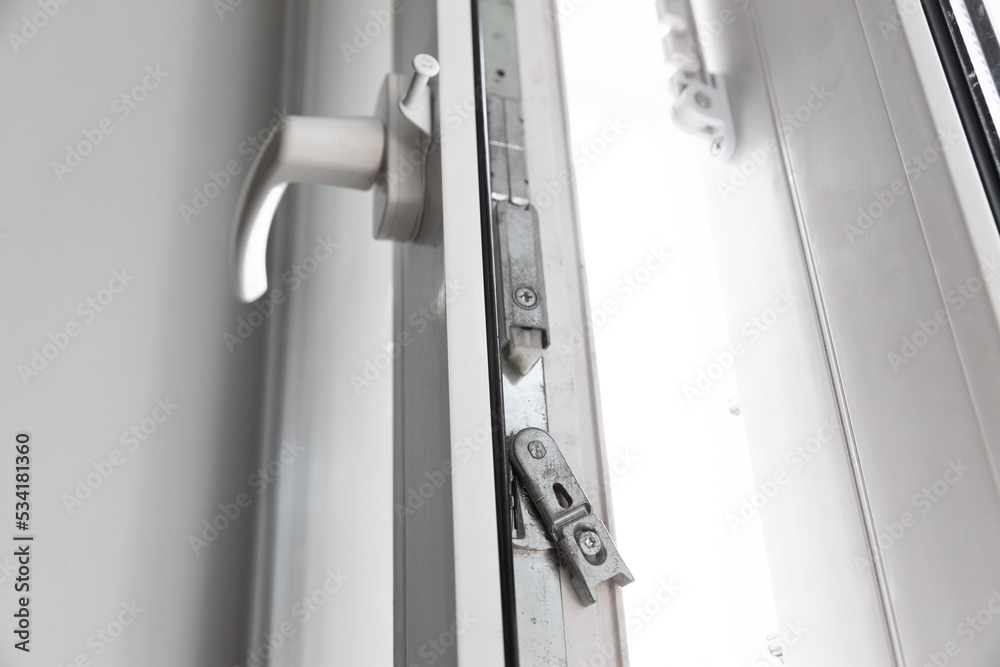 Close-up of a double-glazed balcony frame with a latch and fastening for safe ventilation. Single-sided window handle Close-up of a double-glazed balcony frame with a latch and fastening for safe ventilation. Single-sided window handle