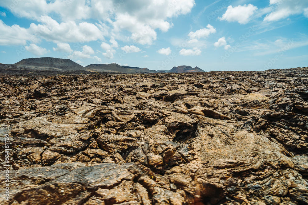 Obraz premium Arid volcanic landscape with lava fields in Timanfaya National Park, Lanzarote, Canary Island, Spain