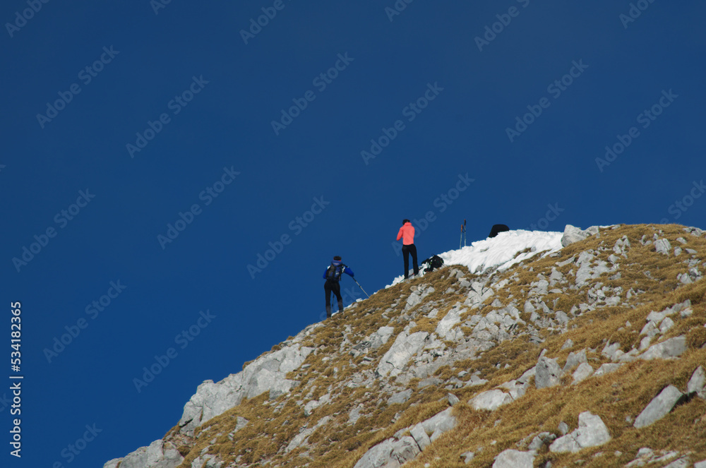 Mountain view with hikers on a snowy mountain ridge