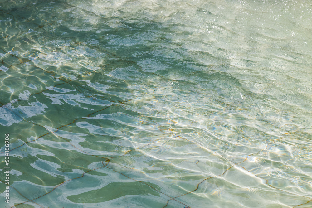 The texture of the spreading water in the fountain, swaying in the sunlight