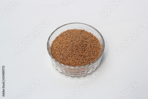 Mustard seeds on a glass bowl, mustard seeds on white background