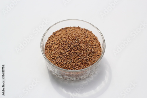 Mustard seeds on a glass bowl, mustard seeds on white background