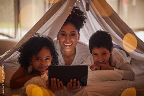 Family portrait, tablet and online app for kids cartoons, streaming and digital night story in blanket fort tent at home. Happy Brazil mother, smile children and reading, playing on internet tech