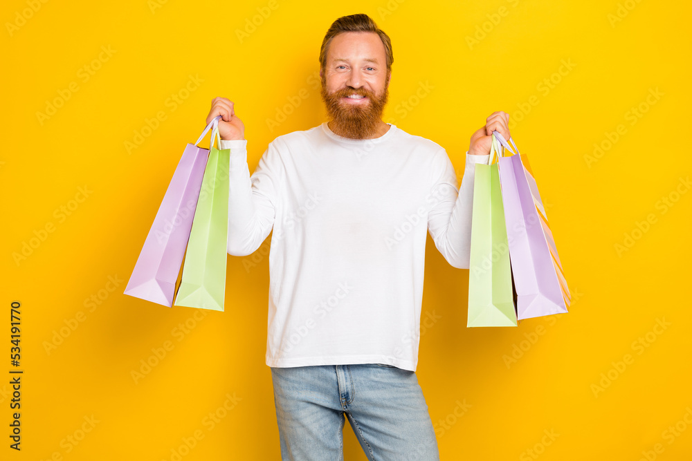 Photo satisfied positive man hand arm hold new clothes choose nice outfit enjoy isolated on yellow color background Photo satisfied positive man hand arm hold new clothes choose nice outfit enjoy isolated on yellow color background