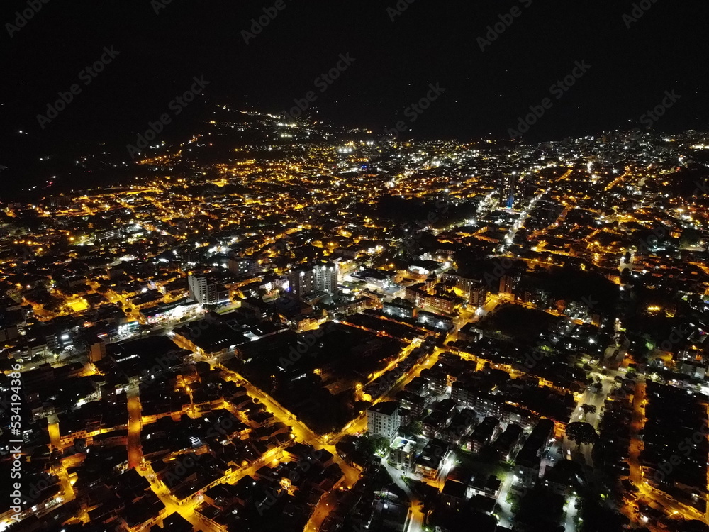 high drone shot of the city of ibagué tolima at night with many lights and lots of color
