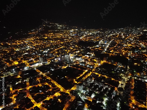 high drone shot of the city of ibagu   tolima at night with many lights and lots of color
