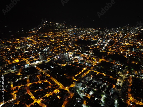 high drone shot of the city of ibagu   tolima at night with many lights and lots of color