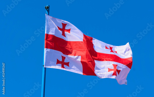 The flag of Georgia is a white banner with five red crosses