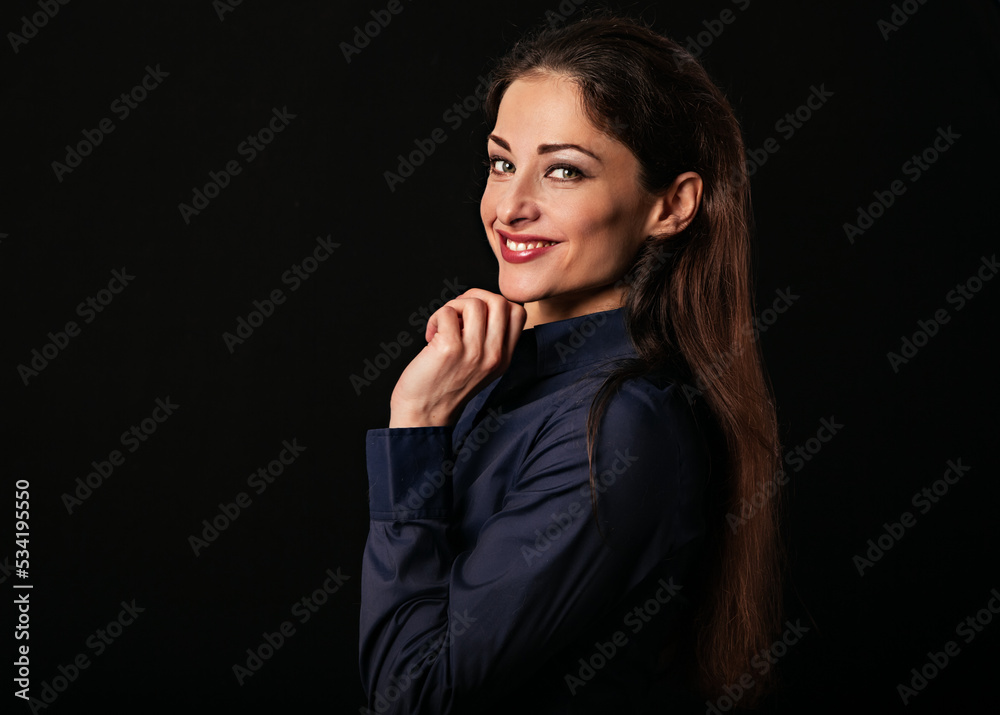 Beautiful thinking toothy smiling business woman with folded arms and hand under the face in blue shirt on black background with empty copy space for text. Closeup Beautiful thinking toothy smiling business woman with folded arms and hand under the face in blue shirt on black background with empty copy space for text. Closeup