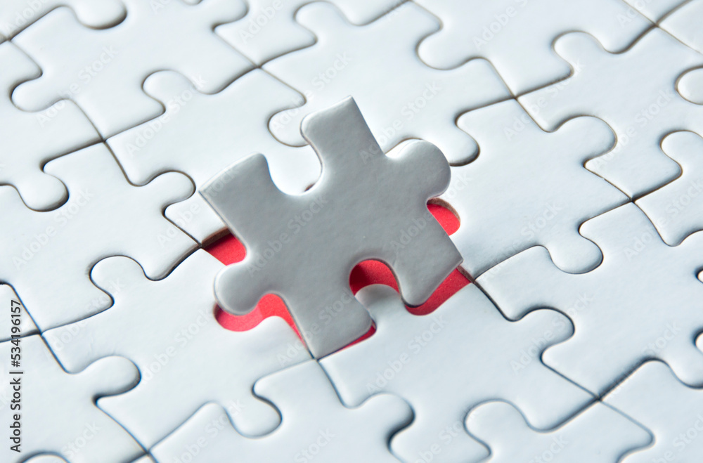 White jigsaw puzzle on red cover background with customizable space for text. Copy space and puzzle concept. White jigsaw puzzle on red cover background with customizable space for text. Copy space and puzzle concept.