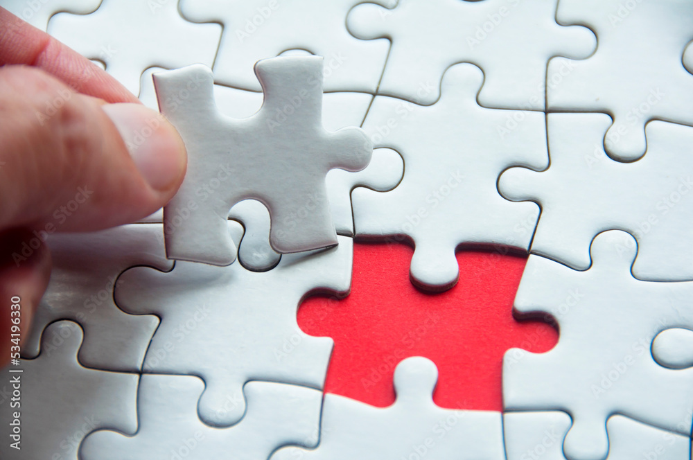 White jigsaw puzzle on red cover background with customizable space for text or idea. Copy space and puzzle concept White jigsaw puzzle on red cover background with customizable space for text or idea. Copy space and puzzle concept