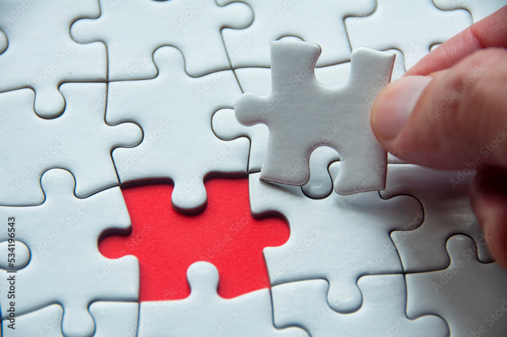 White jigsaw puzzle on red cover background with customizable space for text or idea. Copy space and puzzle concept White jigsaw puzzle on red cover background with customizable space for text or idea. Copy space and puzzle concept