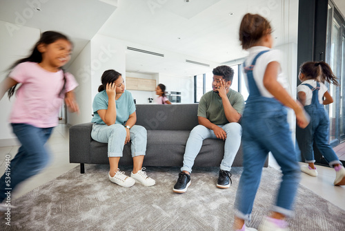 Family, stress or adhd children running fast in house or home living room in energy, fun or play game. Man, woman burnout or anxiety parents with mental health headache from hyper active autism kids