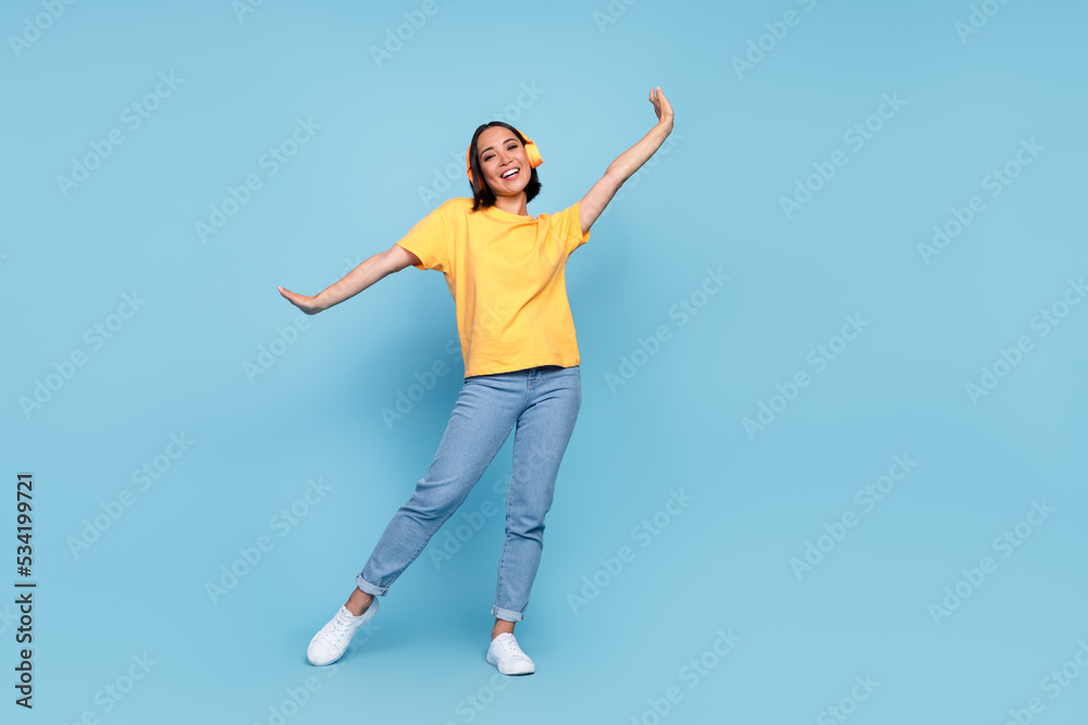 Full length photo of young cute korean woman celebrate dancer empty space headphones advert disco hands up positive vacation isolated on blue color background Full length photo of young cute korean woman celebrate dancer empty space headphones advert disco hands up positive vacation isolated on blue color background