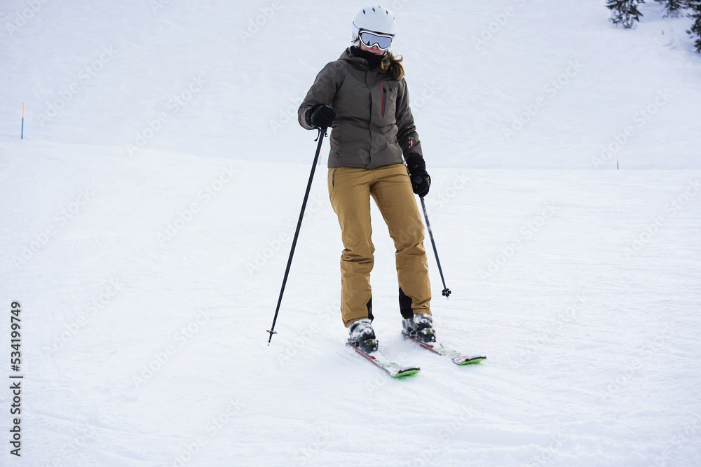 Young female skier skiing in alps mountains on winter weekend - Focus on face