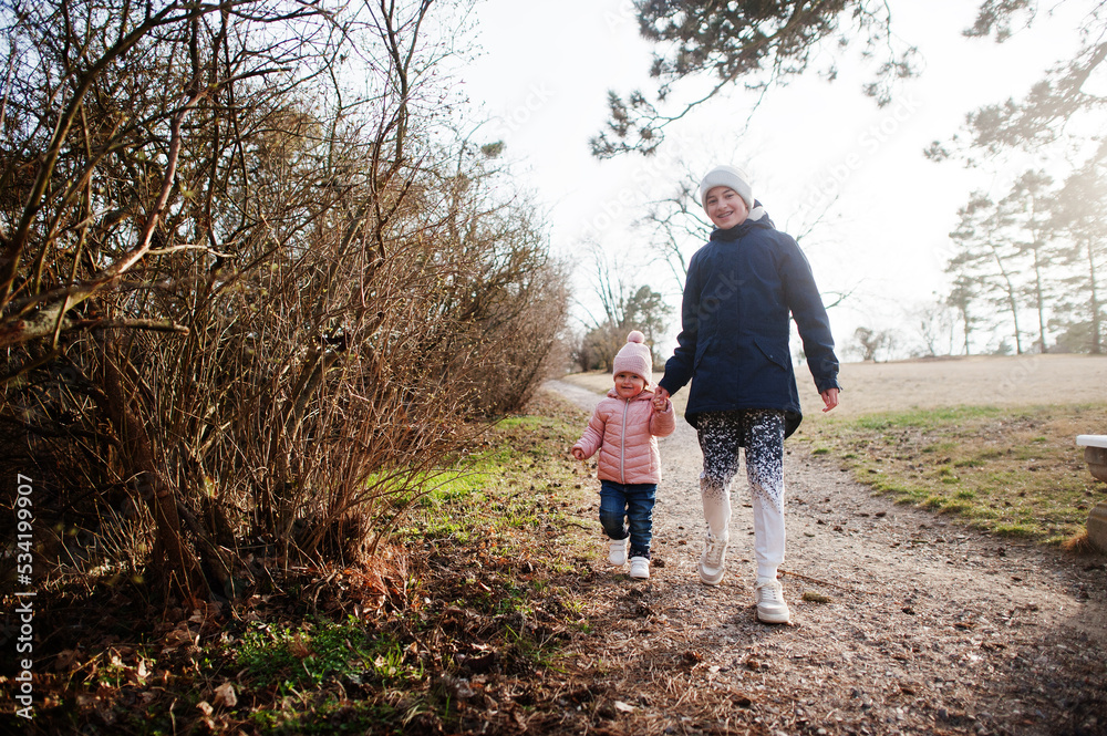 Fototapeta premium Brother holding hand sister walking at Valtice park, Czech Republic.