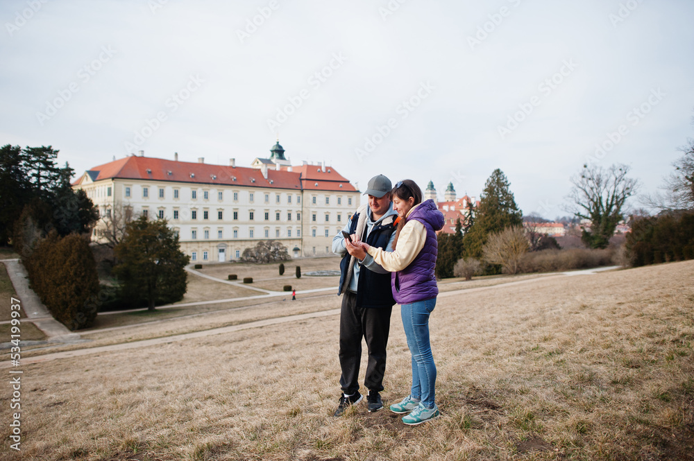 Obraz premium Couple tourist at Valtice palace look on mobile phone, Czech Republic.