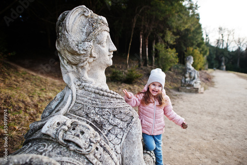Girl near sculpture of female sphinx in Valtice Palace.