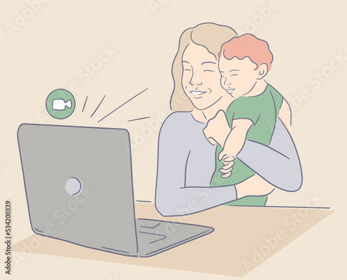 Smiling mother holding baby and doing FaceTime. A woman sits at a table and makes a video call using a home laptop. Mom shows her little baby during an online meeting