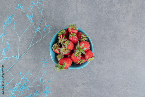 A blue bowl full of delicious strawberries