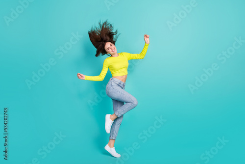 Fototapeta Naklejka Na Ścianę i Meble -  Full length photo of overjoyed lovely person flying hair have good mood isolated on turquoise color background