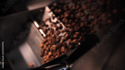 Coffee roaster machine mixing aroma beans.Preparation fresh aroma caffeine on manufacturing warehouse.Close-up Make ready coffee in large roaster falling beans photo