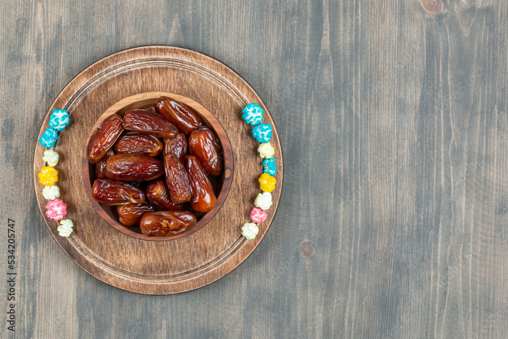 Bowl of dates and popcorns on wooden plate Bowl of dates and popcorns on wooden plate