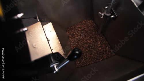Coffee roaster machine mixing aroma beans.Preparation fresh aroma caffeine on manufacturing warehouse.Close-up Make ready coffee in large roaster falling beans