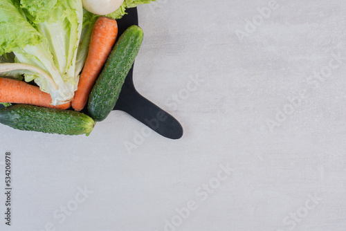 Fresh green vegetables and carrots on black board