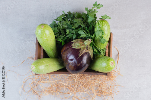 Raw zucchinis and eggplant in wooden box