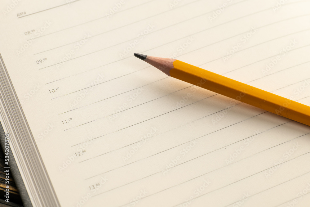 Diary for notes on a wooden table, pen and pencil Diary for notes on a wooden table, pen and pencil