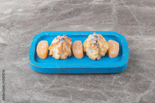 Crumbly cookies and marmelades on a small platter on marble background photo