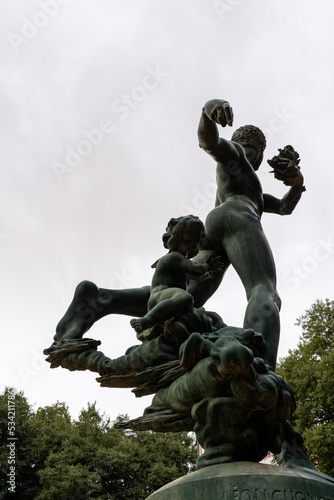 Low-angle view of a naked male and baby sculpture against a dark sky Le Petit Square Garden. Setif  Algeria