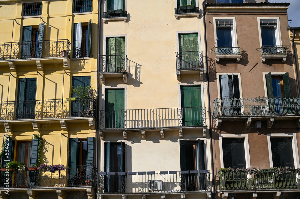 Windows and balconies on colorful building in city centre. Buildings and houses in city of Padua, Italy. Architecture in Tuscany. 