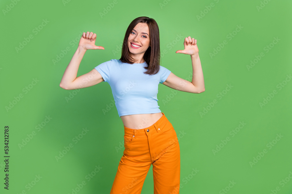 Photo of cheerful adorable lady indicate thumb fingers self herself isolated on green color background Photo of cheerful adorable lady indicate thumb fingers self herself isolated on green color background