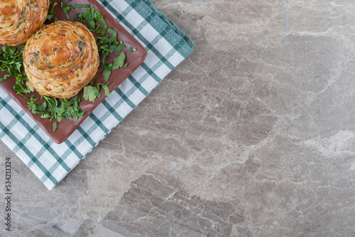 Sour gogals on a platter adorned with chopped parsley leaves, on a towel, on marble background photo